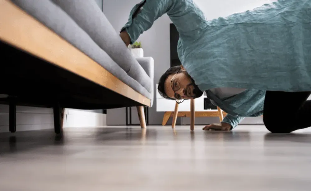 Man Looking For Something Under the Couch